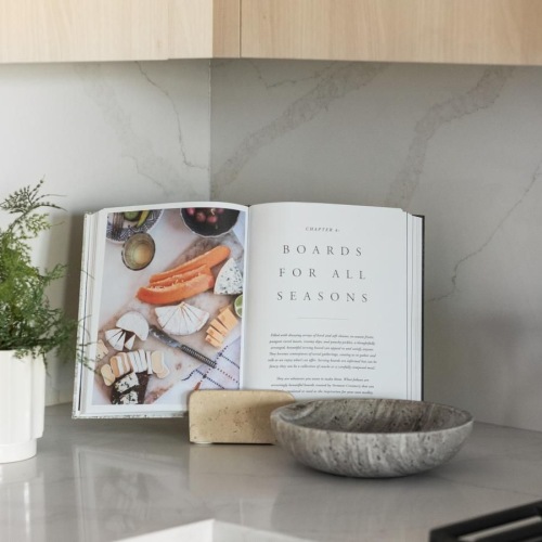 a kitchen with a book and a potted plant