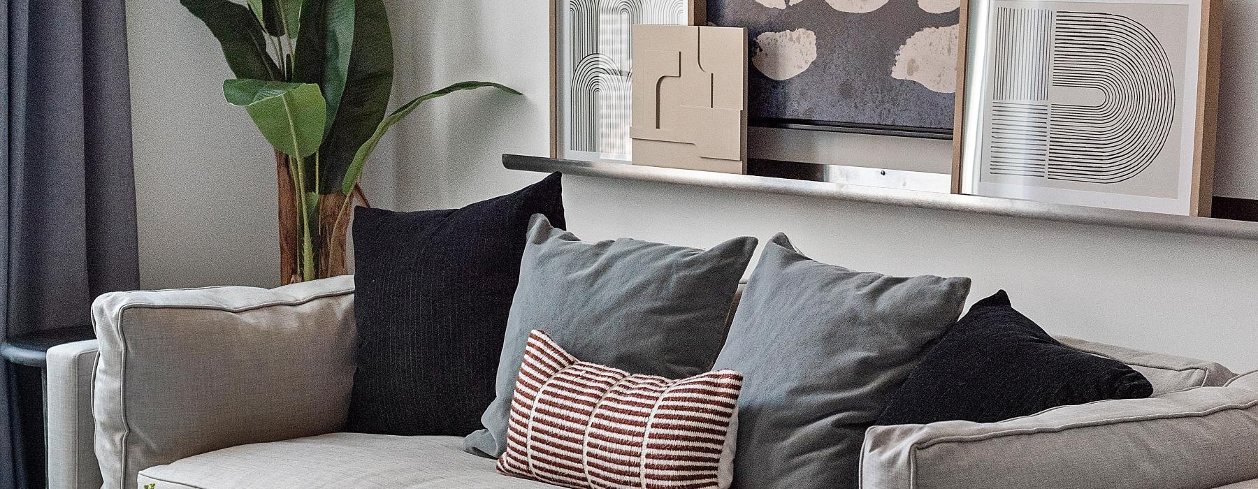 a couch with pillows and a plant