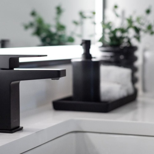a black and white photo of a desk with a plant on it
